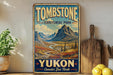 A vintage-style sign for Tombstone Territorial Park in Yukon, Canada, featuring a scenic mountain landscape.