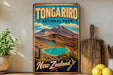 A vintage-style poster of Tongarro National Park in New Zealand, featuring a scenic landscape with a mountain, a lake, and a tropical plant.