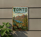 A vintage-style metal sign for the Tonto National Forest in Arizona, featuring a desert landscape with mountains, cacti, and a lake.