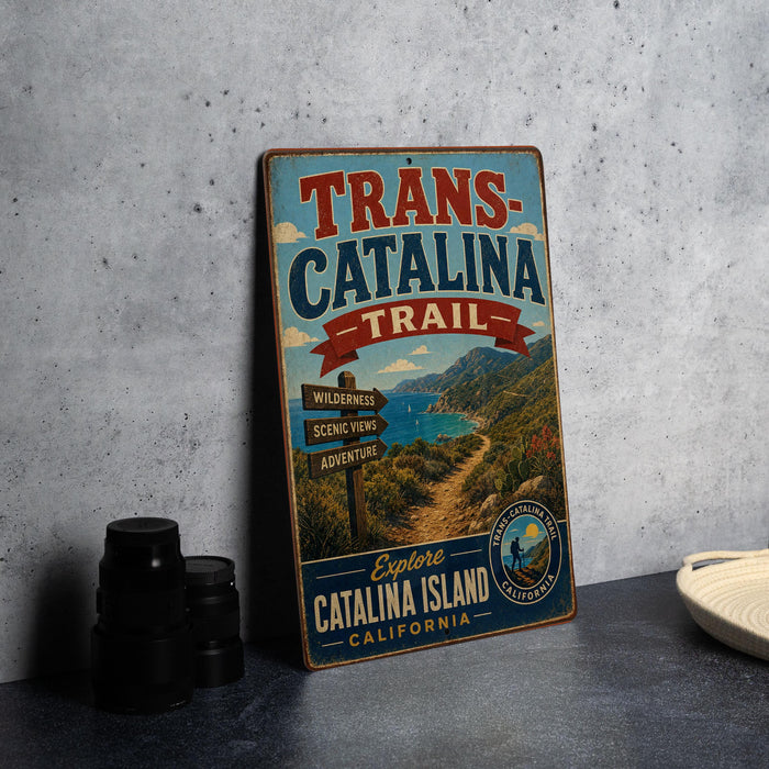 A vintage metal sign for the Trans-Catalina Trail, featuring a scenic landscape with mountains, a river, and a signpost.