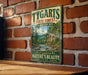 A vintage-style metal sign for Tygarts State Forest in Kentucky, featuring a scenic landscape with a river and mountains.