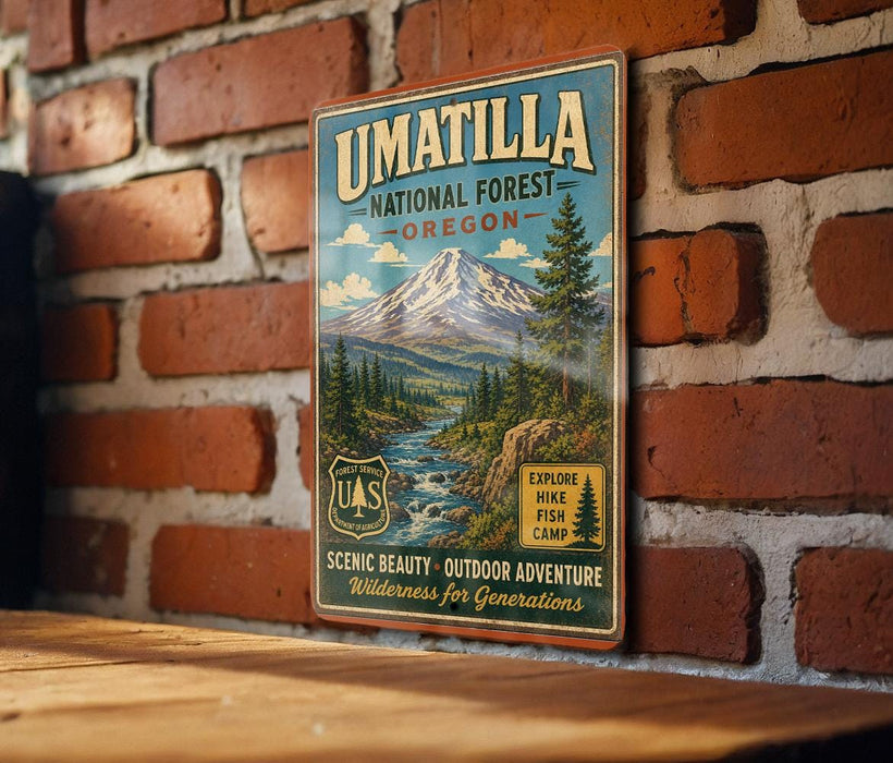 A vintage-style metal sign for the Umatilla National Forest in Oregon, featuring a scenic mountain landscape and outdoor adventure opportunities.