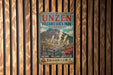 a vintage-style sign for Unzen Volcanic Area Park in Japan, with a mountain landscape and steam vents visible.