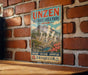 a vintage-style sign for Unzen Volcanic Area Park in Japan, mounted on a brick wall.