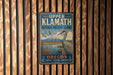 A vintage metal sign for Upper Klamath National Wildlife Refuge in Oregon, featuring a bird and a mountain landscape.