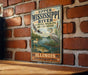 A vintage-style metal sign with illustrations of birds and wildlife, mounted on a brick wall.