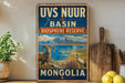 a vintage-style sign for the UVS Nuer Basin Biosphere Reserve in Mongolia, with a mountain landscape and a ram and crane in the foreground.