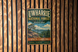 a vintage-style metal sign for the Uwharrie National Forest, mounted on a wooden wall.