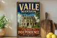 A vintage-style sign for the Vaile Mansion in Independence, Missouri, featuring an illustration of the mansion and the text "A Step Back in Time" and "Independence Missouri".