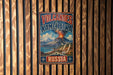 A vintage metal sign with the text "VOLCANoes of Kamchatka" and "RUSSIA" is displayed on a wooden wall.