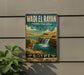 A vintage-style metal sign with the text "Wadi El Rayan" and "Protected Area" is displayed on a wall, featuring an illustration of a waterfall and a gazelle.
