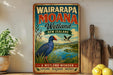A vintage-style sign for Wairarapa Moana Wetland in New Zealand, featuring a blue bird and a scenic landscape.
