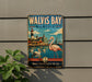 A vintage metal sign for Walvis Bay, Namibia, featuring a pink flamingo, a lighthouse, and a coastal town.