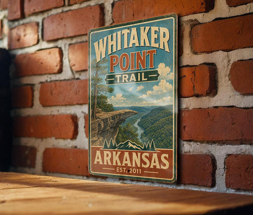 A vintage-style metal sign for Whitaker Point Trail in Arkansas, featuring a scenic landscape with mountains and a river.