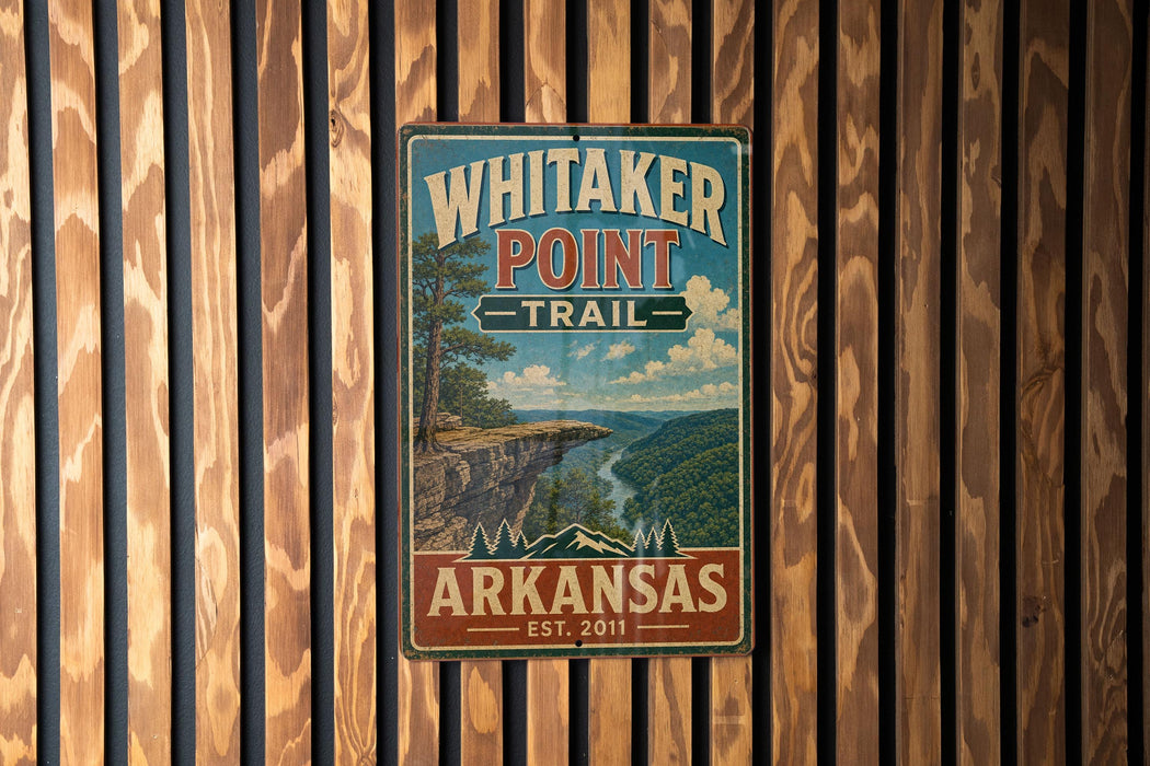 A vintage metal sign for Whitaker Point Trail in Arkansas, featuring a scenic mountain landscape.