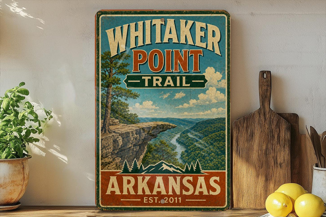 A vintage-style sign for Whitaker Point Trail in Arkansas, featuring a scenic mountain landscape with a river and pine trees.