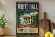A vintage-style sign for the White Hall State Historic House in Kentucky, featuring an illustration of the historic building surrounded by trees and a banner that reads "Historic, Elegant, Timeless".