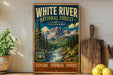 A vintage-style metal sign for the White River National Forest in Colorado, featuring a scenic mountain landscape with a river flowing through it.