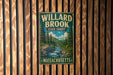 A vintage metal sign for Willard Brook State Forest in Massachusetts, featuring a scenic illustration of a forest and a river.