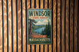 A vintage metal sign for the Windsor State Forest in Massachusetts, featuring a scenic image of a forest and a lake.