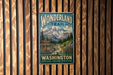 A vintage metal sign for the Wonderland Trail in Washington, featuring a mountain landscape and a trail sign.