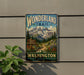 A vintage-style metal sign for the Wonderland Trail in Washington, featuring a mountain landscape and a trail sign.
