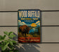 A vintage-style metal sign for Wood Buffalo National Park, Canada, featuring a bison in a scenic landscape.