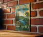 A vintage metal sign with the text "Worthington State Forest" and "New Jersey" is displayed on a brick wall.