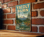 A vintage-style metal sign for Yacolt Burn State Forest in Washington, featuring a scenic mountain landscape with pine trees and a river.