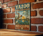A vintage-style metal sign for the YAZOO NATIONAL WILDLIFE REFUGE in Mississippi, featuring a duck and a sunset landscape.