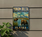 A vintage-style sign for Yukon Delta National Wildlife Refuge in Alaska, featuring a moose and a bear in a scenic landscape with mountains and water.