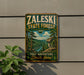 A vintage-style metal sign for the Zaleski State Forest in Ohio, featuring a scenic landscape with pine trees, a river, and mountains.