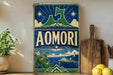 A vintage-style metal sign with the word "AOMORI" prominently displayed, featuring a mountain landscape, a ship, and apples.