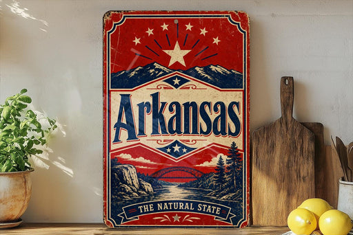 A vintage-style sign for Arkansas, featuring a red, white, and blue design with a star and mountains, is displayed on a shelf next to a wooden cutting board and some lemons.