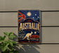 a vintage-style sign with the word "AUSTRALIA" prominently displayed, along with a kangaroo and other Australian symbols. The sign is mounted on a wall, and there is a plant visible to the left of the sign.