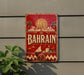 a vintage-style sign with the word "BAHRAIN" prominently displayed, along with a cityscape and a sailboat illustration.