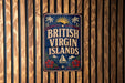 A vintage-style sign that reads "British Virgin Islands" is displayed on a wooden wall.
