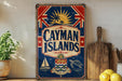 A vintage-style sign for the Cayman Islands, featuring a Union Jack flag, a sailboat, and a turtle, is displayed on a shelf next to a wooden cutting board and some lemons.