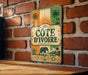 a vintage-style metal sign with a tropical theme, hanging on a brick wall.