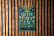 A vintage metal sign with the text "Green Turtle Cay" is displayed on a wooden wall.