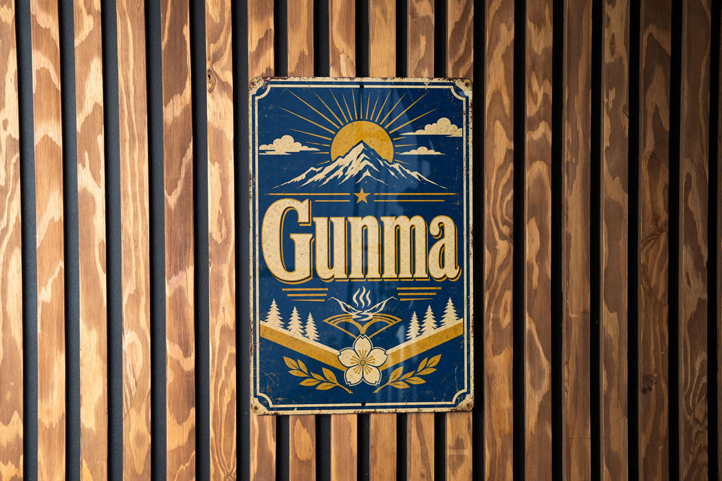 a blue and gold sign with the word "Gunma" on it, mounted on a wooden wall.