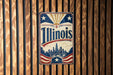 A vintage-style sign that reads "Illinois" is displayed on a wooden wall.