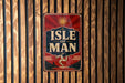 A vintage-style sign with the text "ISLE OF MAN" displayed prominently against a wooden background.