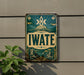 a vintage-style sign with the word "IWATE" prominently displayed, mounted on a wall.