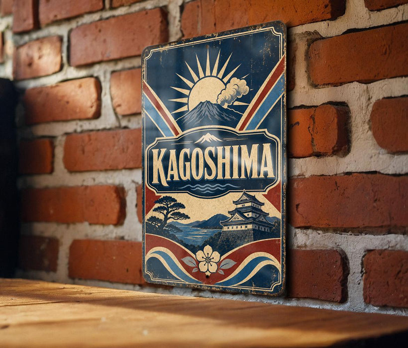 A vintage-style metal sign with the word "KAGOSHIMA" prominently displayed, featuring a sun and mountain landscape design.