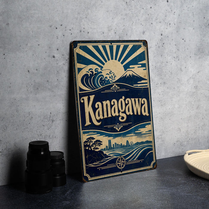 A vintage-style metal sign with the word "Kanagawa" prominently displayed, featuring a sun and mountain landscape design.