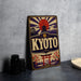 A vintage-style sign for "KYOTO" featuring a sun and pagoda design, with the word "KYOTO" prominently displayed in the center.