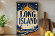A vintage-style sign for Long Island, featuring a lighthouse, sun, and ocean, is displayed on a shelf next to a wooden cutting board and some lemons.