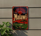 a vintage Malawi beer sign with a sun and landscape design, mounted on a wall.