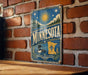 A vintage-style metal sign with the word "MINNESOTA" prominently displayed, featuring a sun, stars, and a loon.